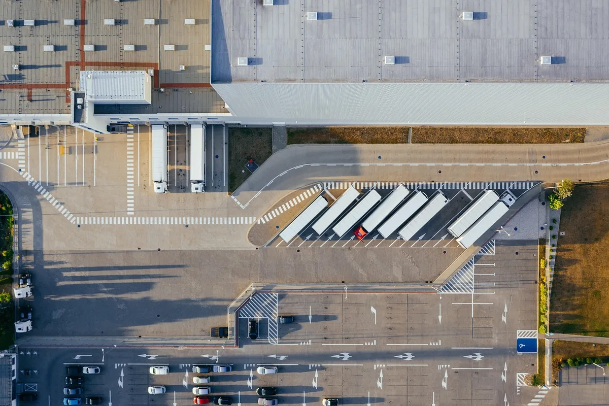 Aerial view of semi trucks docked at a modern distribution center